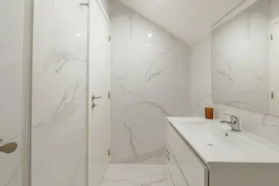 a white bathroom with a shower and a sink at Rooftop Constituicao by Vacationy in Porto