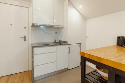 a kitchen with white cabinets and a counter top at Rooftop Constituicao by Vacationy in Porto