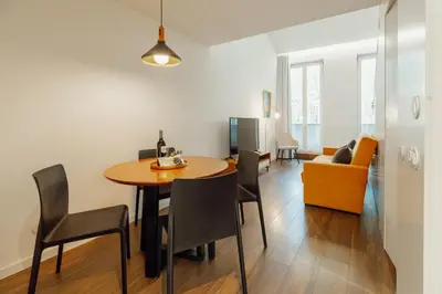 a living room with a table and chairs and a couch at Elegant Marques Duplex by Vacationy in Porto