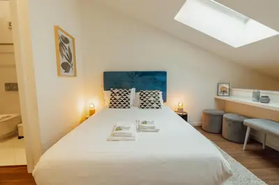 a bedroom with a large white bed with a skylight at Elegant Marques Duplex by Vacationy in Porto