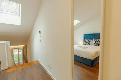a bedroom with a bed and a mirror at Elegant Marques Duplex by Vacationy in Porto