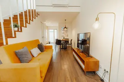 a living room with a couch and a television at Elegant Marques Duplex by Vacationy in Porto
