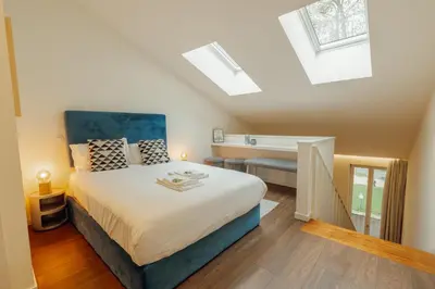 a bedroom with a large bed and skylights at Elegant Marques Duplex by Vacationy in Porto
