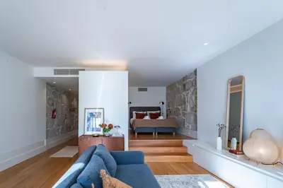 a living room with a blue couch and a bedroom at Nomads Lux - 1BD The Comfort Square in Porto in Porto