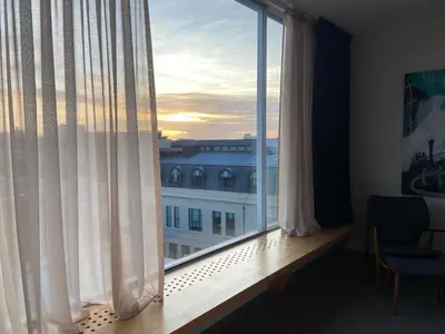 a living room with a chair and a window at Urban Residences Sacadura in Porto
