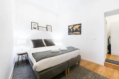 a white bedroom with a bed and a table at Cantinho do Porto - Metro 1 Minute Away in Porto
