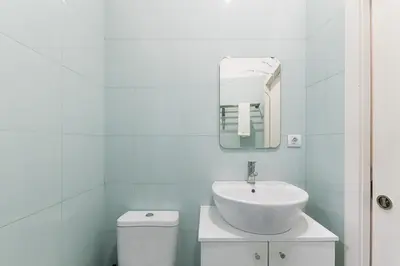 a white bathroom with a sink and a toilet at Cantinho do Porto - Metro 1 Minute Away in Porto