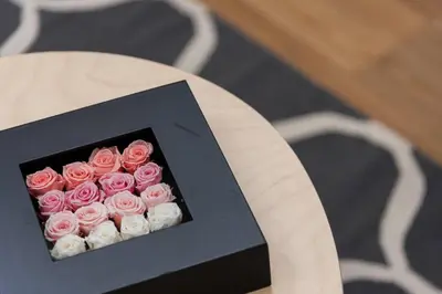 a bunch of pink roses in a box on a table at Cantinho do Porto - Metro 1 Minute Away in Porto