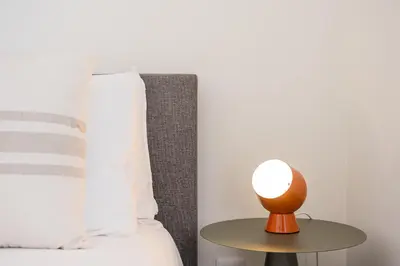 a lamp on a table next to a bed at Sunny one bedroom apartment in Porto
