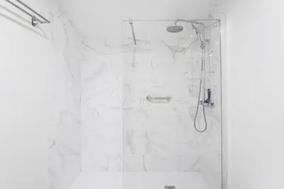 a bathroom with a shower with white marble at Sunny one bedroom apartment in Porto
