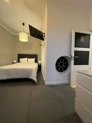 a bedroom with a bed and a door with a fan at Good end Oporto View in Porto