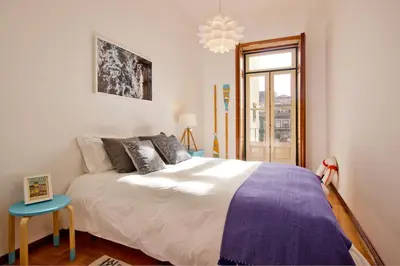 a bedroom with a large white bed and a window at Porto Pacific - Rua das Flores - Flower Street in Porto