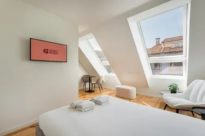 a bedroom with a white bed and a large window at GuestReady - Urban retreat in Boavista in Porto