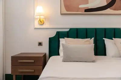a bed with a green headboard and a night stand at Cosy Flat in Porto with Private Patio & Garden Area by Lisbeyond in Porto