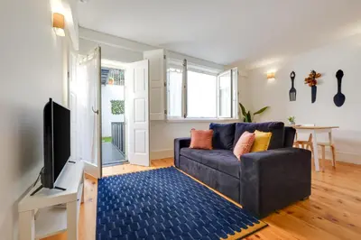 a living room with a couch and a tv at 1-Bedroom Apartment with Terrace next to Bonfim Metro Station in Porto