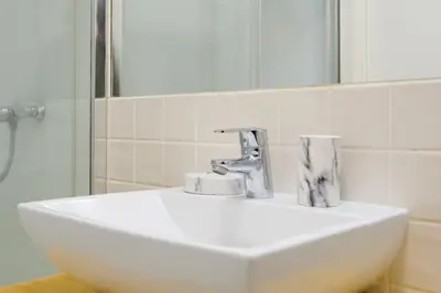 a white sink in a bathroom with a mirror at 1-Bedroom Apartment with Terrace next to Bonfim Metro Station in Porto