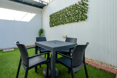 a table with four chairs and a plant on a wall at 1-Bedroom Apartment with Terrace next to Bonfim Metro Station in Porto