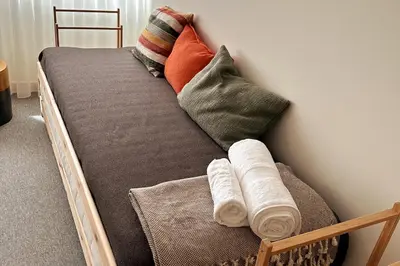 a wooden bed with pillows and towels on it at BOLHÃO - Stylish downtown two bedroom apartment in Porto