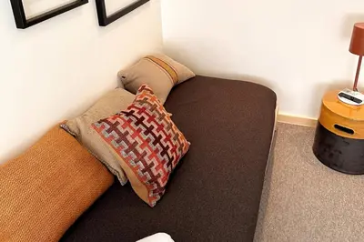 a couch with two pillows on it in a room at BOLHÃO - Stylish downtown two bedroom apartment in Porto