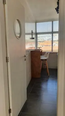 a bathroom with a sink and a table and a mirror at T2P Pilar House in Vila Nova de Gaia