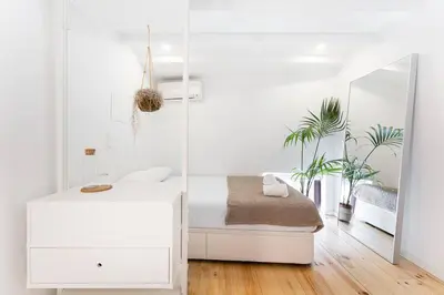 a white bedroom with a bed and a mirror at Art Wine Loft with oPorto view! in Vila Nova de Gaia