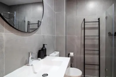 a bathroom with a sink and a mirror and a toilet at Bright 3BR Flat near Douro with AC by LovelyStay in Vila Nova de Gaia