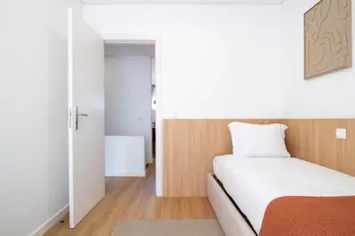 a small bedroom with a bed and a door at Bright 3BR Flat near Douro with AC by LovelyStay in Vila Nova de Gaia
