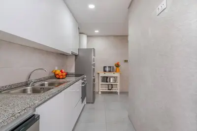 a kitchen with a sink and a refrigerator at Bright & Cozy Apartment by HostWise in Vila Nova de Gaia