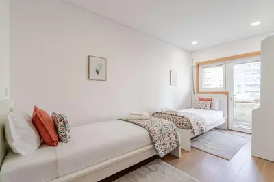 a white room with two beds and a window at Bright & Cozy Apartment by HostWise in Vila Nova de Gaia