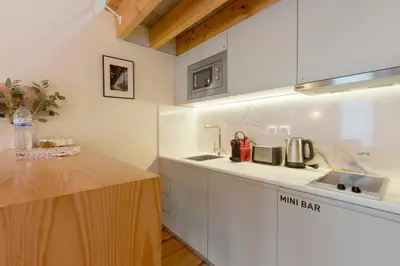 a wooden table with two plates and wine bottles at Orange Apartments B in Porto