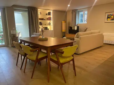 a living room with a wooden table and yellow chairs at Casa de Duque de Loulé - Apartments by RealuptownPorto in Porto