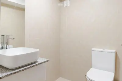 a white bathroom with a sink and a toilet at Bom Sucesso Executive Suites by HostWise in Porto