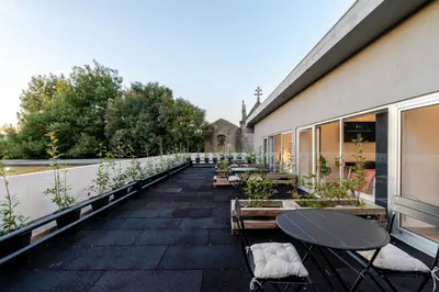 a patio with tables and chairs on a building at Bom Sucesso Executive Suites by HostWise in Porto