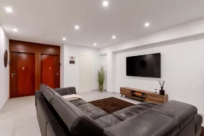a living room with a couch and a flat screen tv at Bom Sucesso Executive Suites by HostWise in Porto
