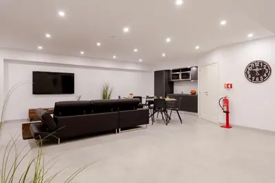 a living room with a couch and a dining room at Bom Sucesso Executive Suites by HostWise in Porto