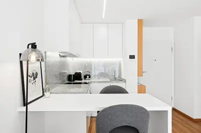 a kitchen with white cabinets and a counter top at New Luxurious, Spacious Studio With Parking in Vila Nova de Gaia