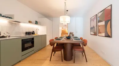 a kitchen and dining room with a wooden table and chairs at Ando Living - São Miguel House in Porto