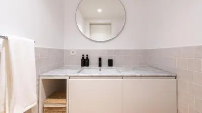 a bathroom with a white sink and a mirror at Ando Living - São Miguel House in Porto