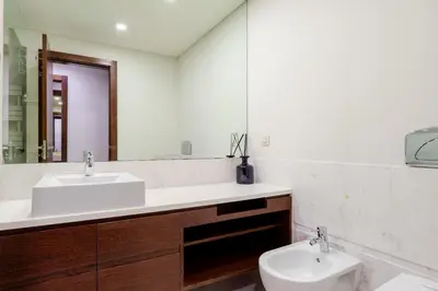 a bathroom with a sink and a toilet and a mirror at Modern & Spacious Flat with Garage by HostWise in Vila Nova de Gaia
