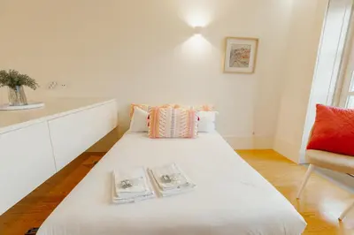 a white bed with two books on it in a room at Historical Taipas Apartments by Vacationy in Porto