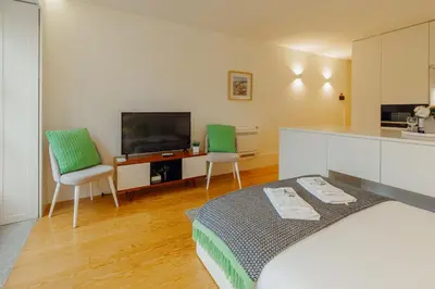 a room with a bed and two chairs and a kitchen at Historical Taipas Apartments by Vacationy in Porto