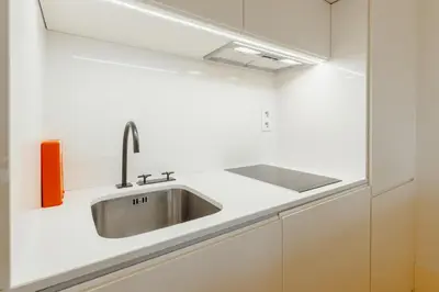 a kitchen with a sink in a white kitchen at Historical Taipas Apartments by Vacationy in Porto