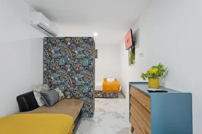 a living room with a yellow bed and a couch at GuestReady - Enjoy Comfort in Porto in Porto