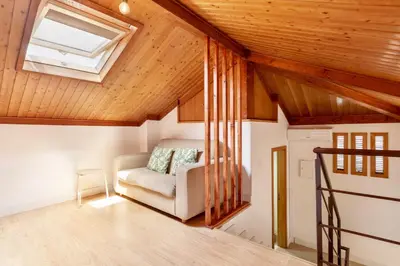 a attic room with a bed and a skylight at D&S - Porto São Bento Apartments in Porto