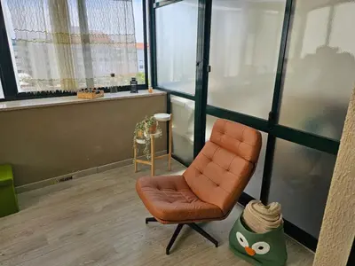 an office with an orange chair in a room with windows at Fabulous Antero De Quental in Porto