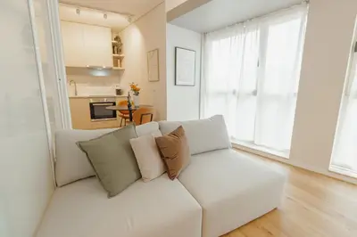 a white couch in a living room with a kitchen at Bright Window Apartment by Vacationy in Porto