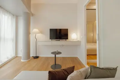 a living room with a couch and a tv on a wall at Bright Window Apartment by Vacationy in Porto
