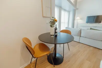 a living room with a table and chairs and a couch at Bright Window Apartment by Vacationy in Porto