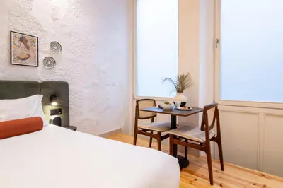 a bedroom with a bed and a table and chairs at Bainharia 82 by LovelyStay in Porto