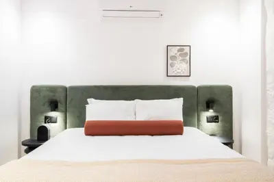 a bedroom with a white bed with a green headboard at Bainharia 82 by LovelyStay in Porto